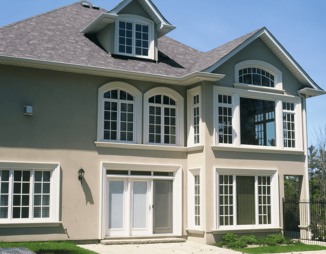 Modern house with large windows and lawn.