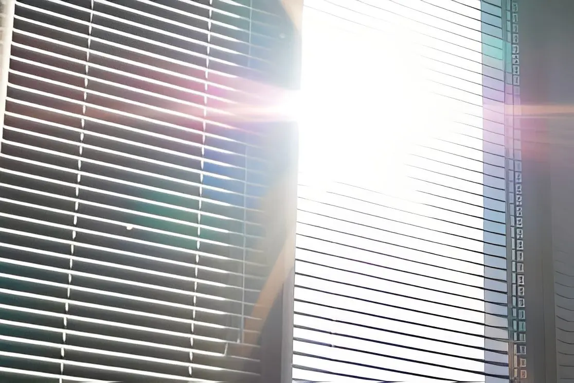 Sunlight streaming through window blinds.